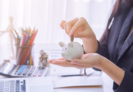 woman inserting coin in piggy bank